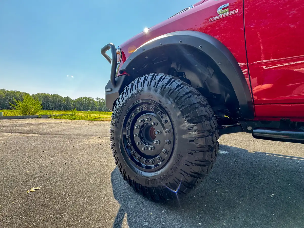 Front wheel close-up from side angle with tire tread and fender edge.